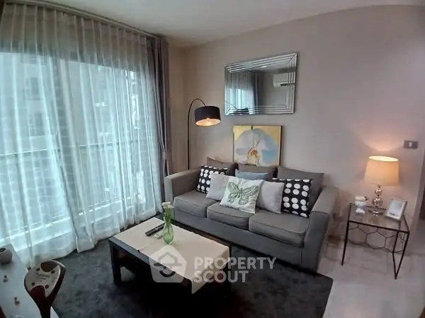 Chic modern living room with stylish decor and large window, perfect for relaxation.
