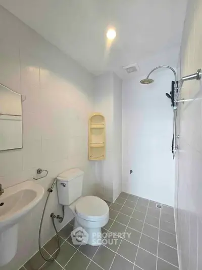 Modern bathroom with sleek fixtures and minimalist design, featuring a shower and toilet.