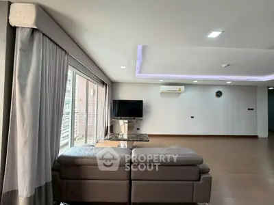 Spacious modern living room with large windows and sleek furniture