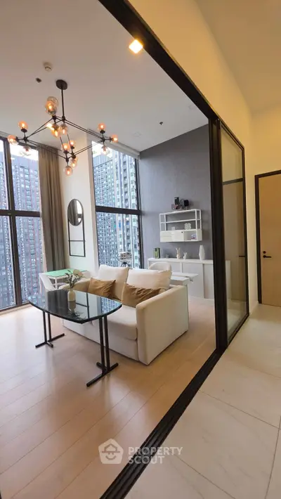 Modern living room with floor-to-ceiling windows and stylish chandelier in high-rise apartment.