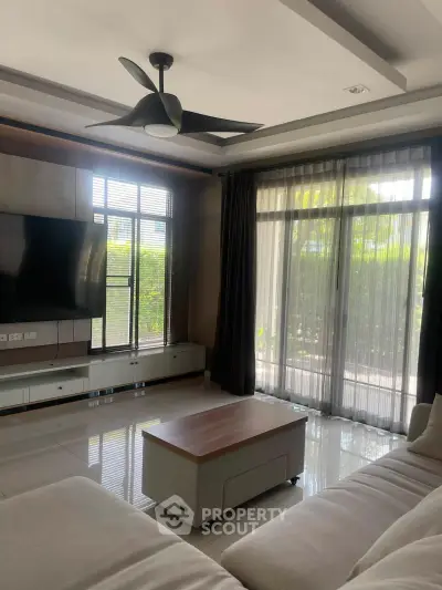 Spacious living room with modern decor and large windows offering natural light.