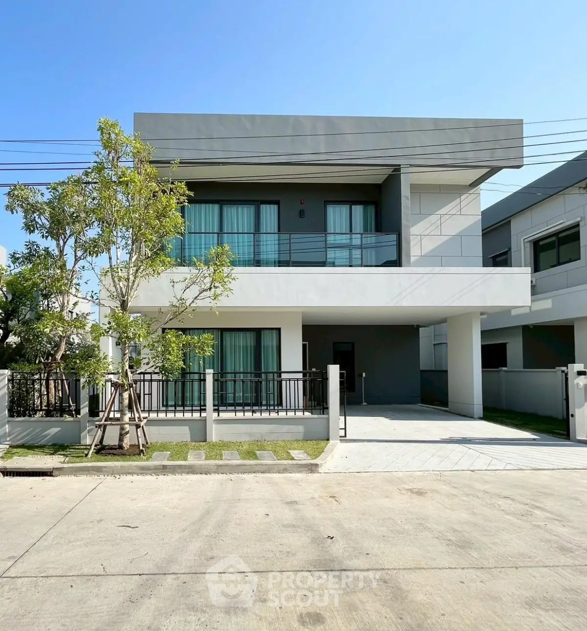 Modern two-story house with sleek design and spacious balcony in a serene neighborhood.