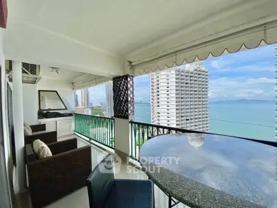 Stunning high-rise balcony with ocean view and modern seating area.