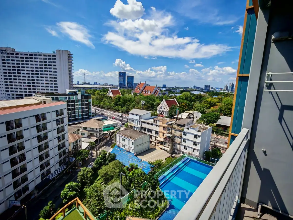 Stunning urban view from a high-rise balcony overlooking cityscape and pool.