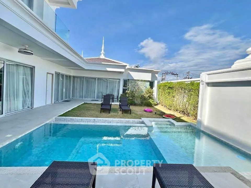 Luxurious villa with private pool and sun loungers, perfect for relaxation.