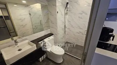 Modern bathroom with marble tiles and glass shower enclosure