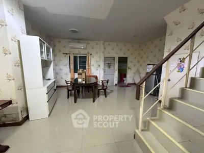 Spacious living room with elegant staircase and dining area, perfect for family gatherings.