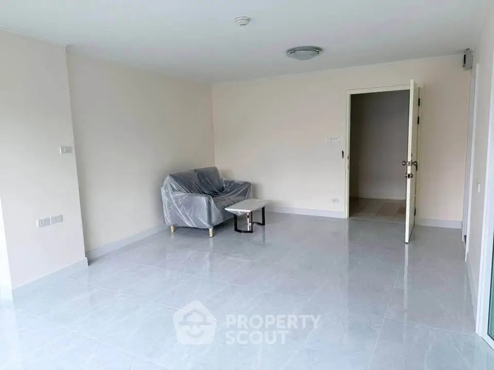 Spacious unfurnished living room with tiled flooring and natural light.