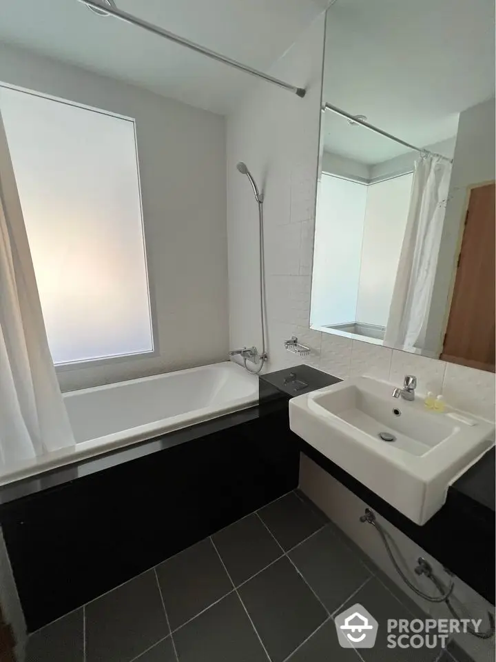 Modern bathroom with sleek design featuring bathtub and large mirror