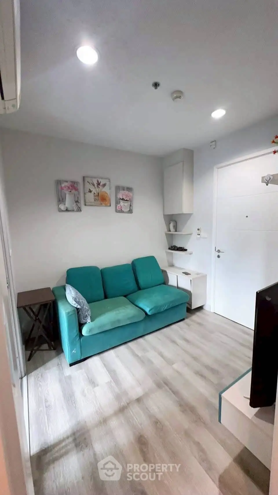 Cozy living room with teal sofa and modern decor in a stylish apartment.
