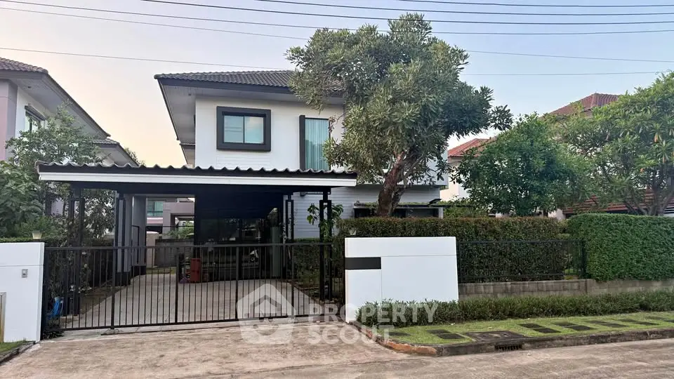 Charming two-story house with lush garden and spacious driveway in a serene neighborhood.