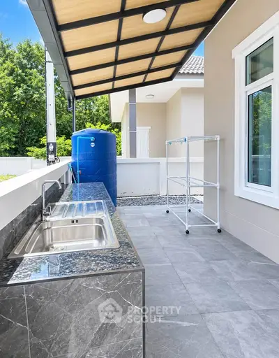 Modern outdoor kitchen with sleek countertops and spacious layout in a contemporary home setting.