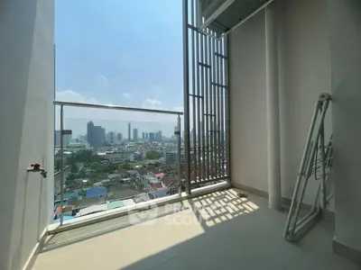 Stunning city view from high-rise balcony with modern railing and ample sunlight.