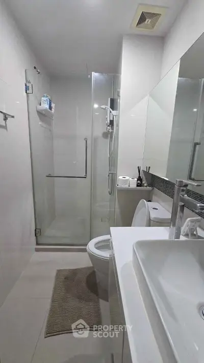 Modern bathroom with glass shower and sleek fixtures in a contemporary apartment.