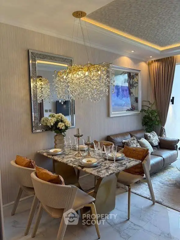 Luxurious dining and living area with elegant chandelier and modern decor