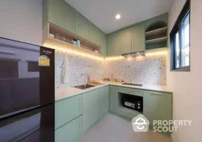 Modern kitchen with mint green cabinets and sleek appliances