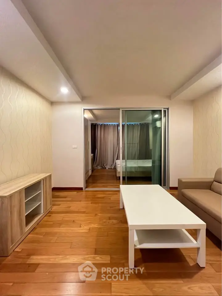 Spacious living room with wooden flooring and modern furniture in a stylish apartment.