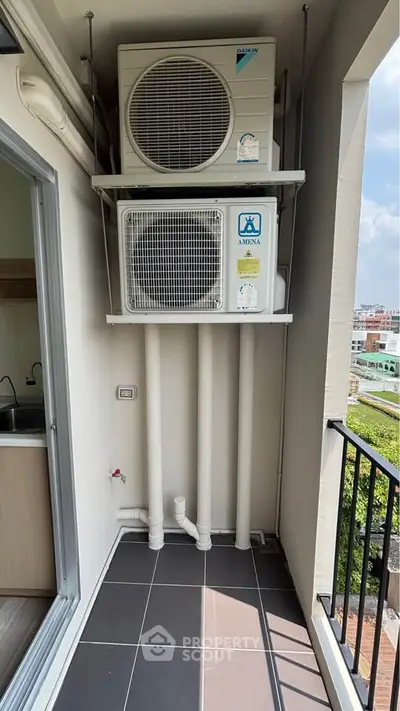 Compact balcony with air conditioning units and city view, ideal for urban living.