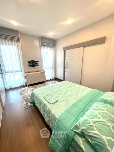 Modern bedroom with stylish decor and natural light, featuring a cozy bed and sleek furniture.