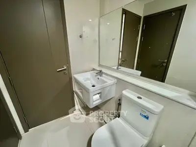 Modern bathroom with sleek fixtures and large mirror in a contemporary apartment.