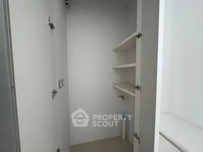 Minimalist storage space with white shelves and cabinets