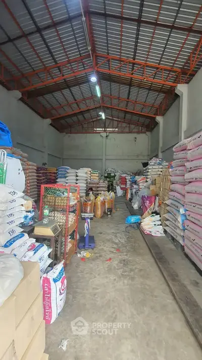 Spacious warehouse interior with high ceilings and stacked goods, ideal for storage solutions.