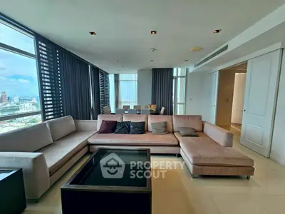 Spacious modern living room with panoramic city views and elegant furnishings.