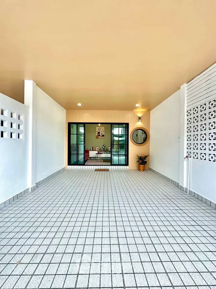 Spacious tiled entrance with modern design and large sliding glass doors.