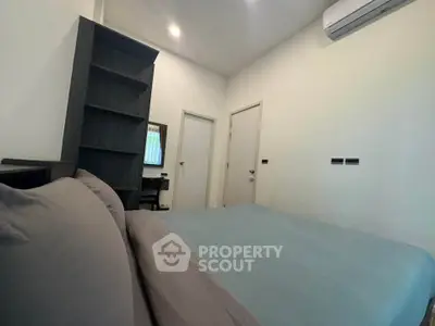 Cozy bedroom with modern furnishings and air conditioning in a stylish apartment.