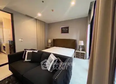 Modern bedroom with stylish decor and cozy seating area in a contemporary apartment.