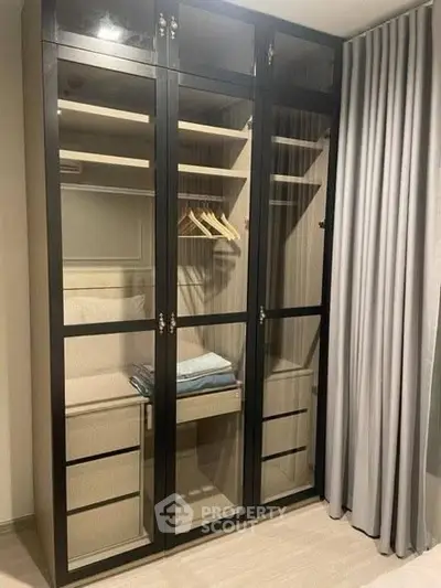 Elegant glass-door wardrobe in a modern bedroom with stylish curtains