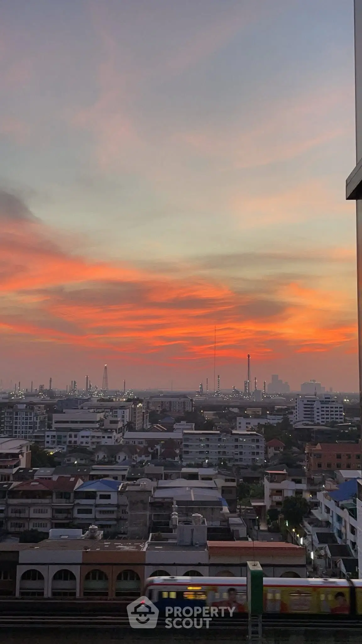 Stunning cityscape view at sunset with vibrant sky colors, perfect for urban living enthusiasts.
