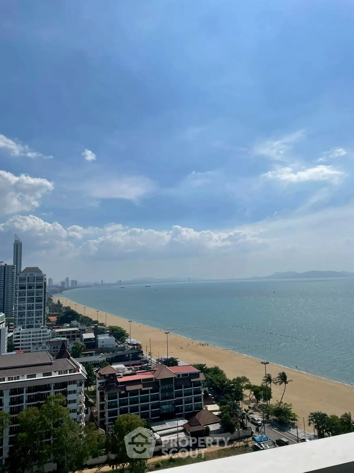 Stunning beachfront view from high-rise building overlooking ocean and city skyline.