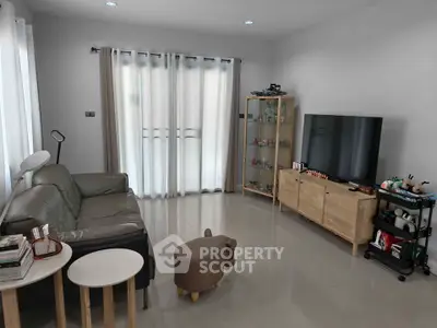 Modern living room with sleek furniture and large TV, perfect for relaxation and entertainment.