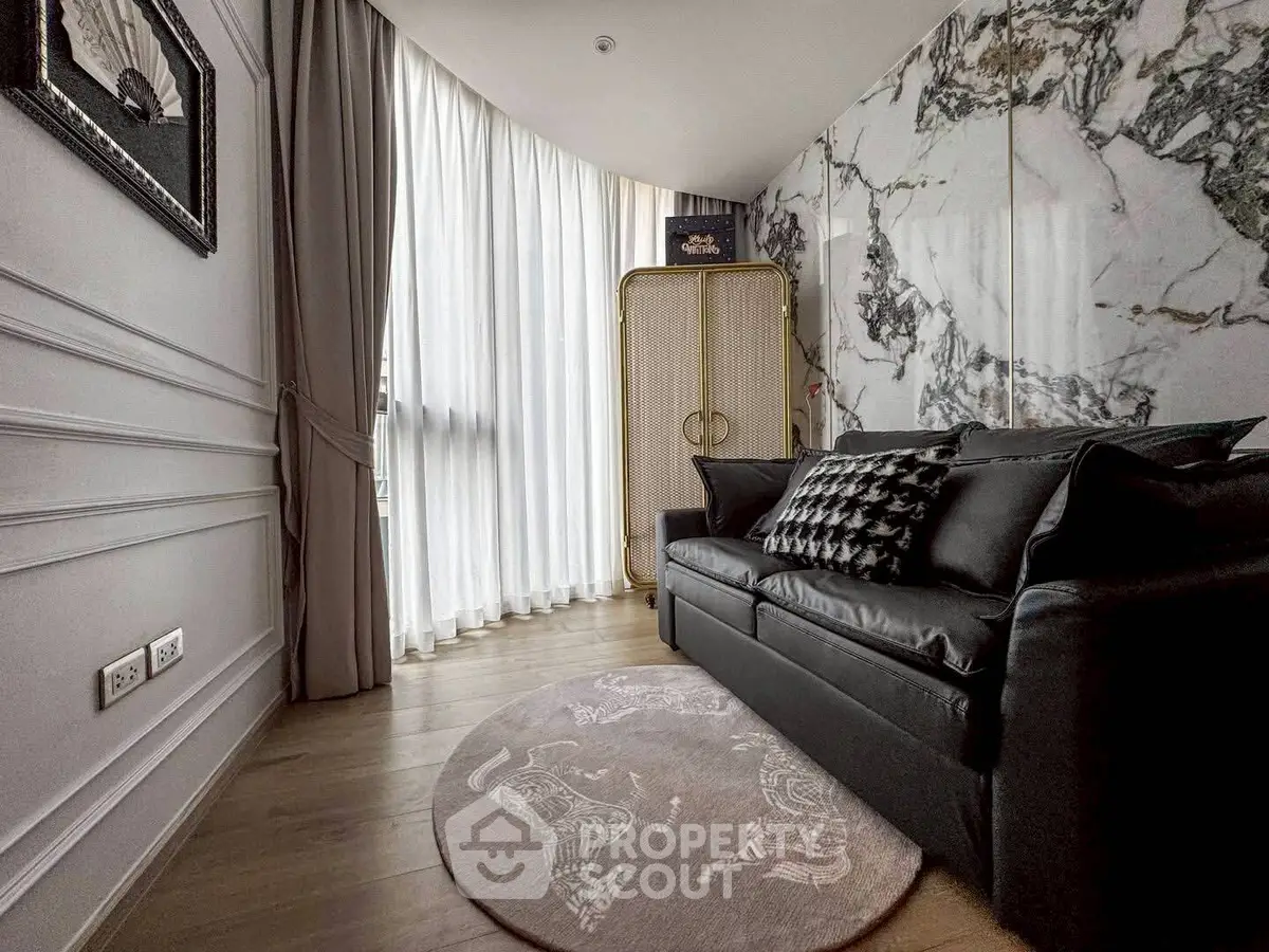 Luxurious living room with elegant marble wall and plush black sofa in modern apartment.