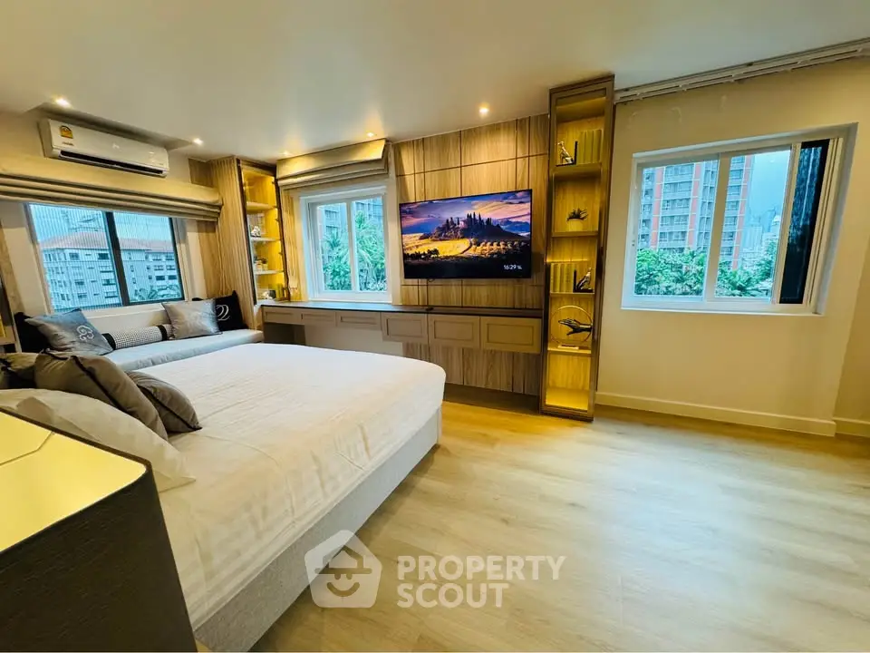 Luxurious bedroom with modern decor and city view, featuring a large bed and built-in TV unit.