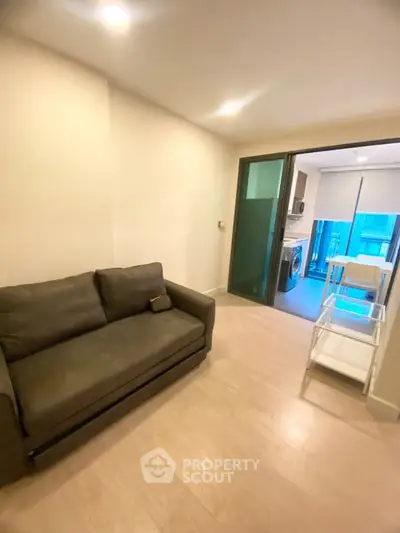 Modern living room with cozy sofa and open kitchen layout in a stylish apartment.