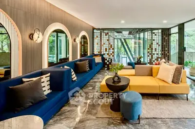 Luxurious modern living room with stylish furniture and large windows offering natural light and garden views.