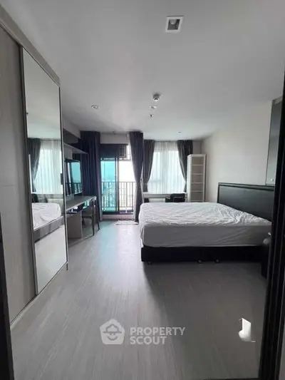 Spacious modern bedroom with balcony and ample natural light