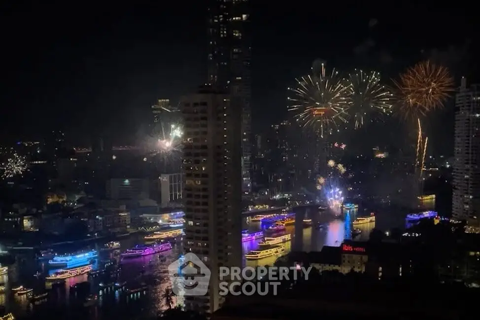 Stunning cityscape view with vibrant fireworks over a river at night, showcasing urban nightlife.