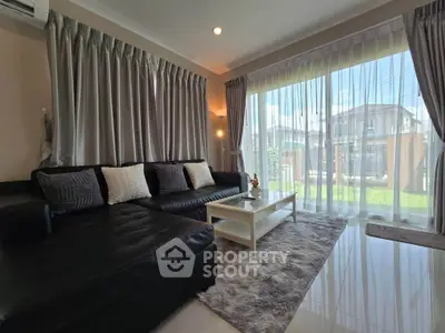 Spacious living room with large windows and modern decor, offering a bright and inviting atmosphere.