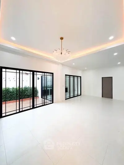 Spacious modern living room with large windows and garden view, perfect for family gatherings.