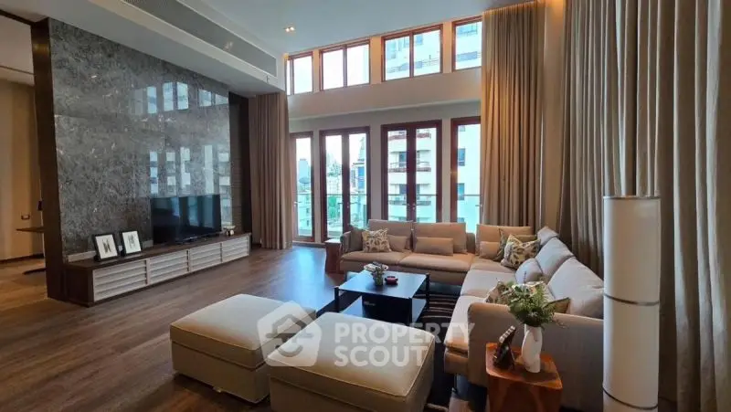 Luxurious living room with high ceilings and large windows in modern apartment.