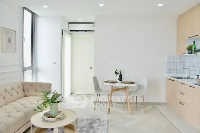 Modern open-plan living room with stylish kitchen and dining area, featuring elegant decor and natural light.