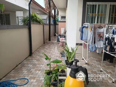 Charming outdoor patio with laundry area and potted plants in a cozy residential setting.