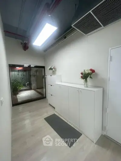 Modern hallway with sleek white cabinets and floral decor