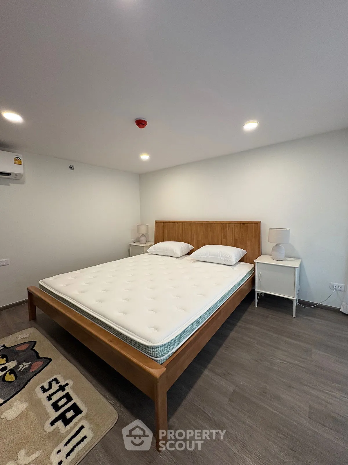 Spacious modern bedroom with wooden bed frame and stylish decor
