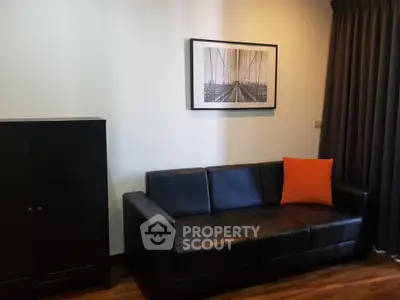 Modern living room with black leather sofa and stylish decor