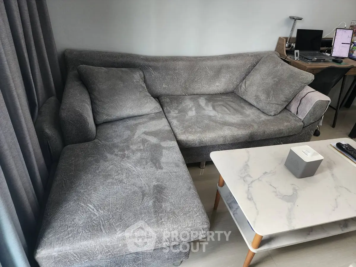 Modern living room with stylish gray sofa and marble coffee table, perfect for relaxation and entertainment.