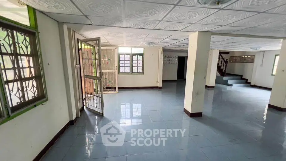 Spacious open-plan interior with tiled flooring and ample natural light, ideal for versatile living arrangements.